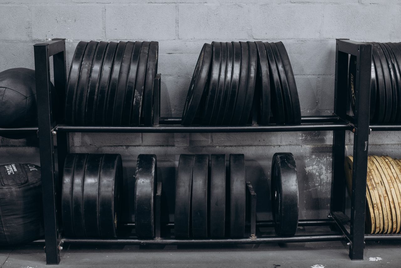 Disques de musculation rangés sur un support dans une salle de sport